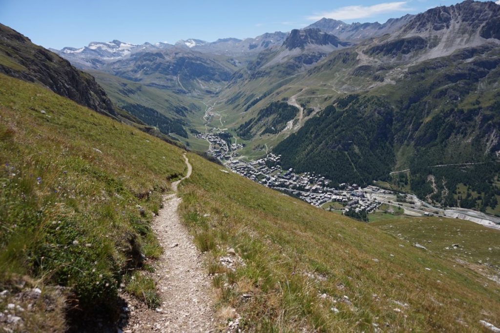 Un sentier de randonnée avec la station de Val d'Isère au second plan.