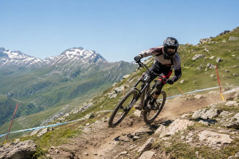 Pilote de VTT de descente sur une piste rocheuse en montagne lors des Championnats de France DH aux Menuires 2026.