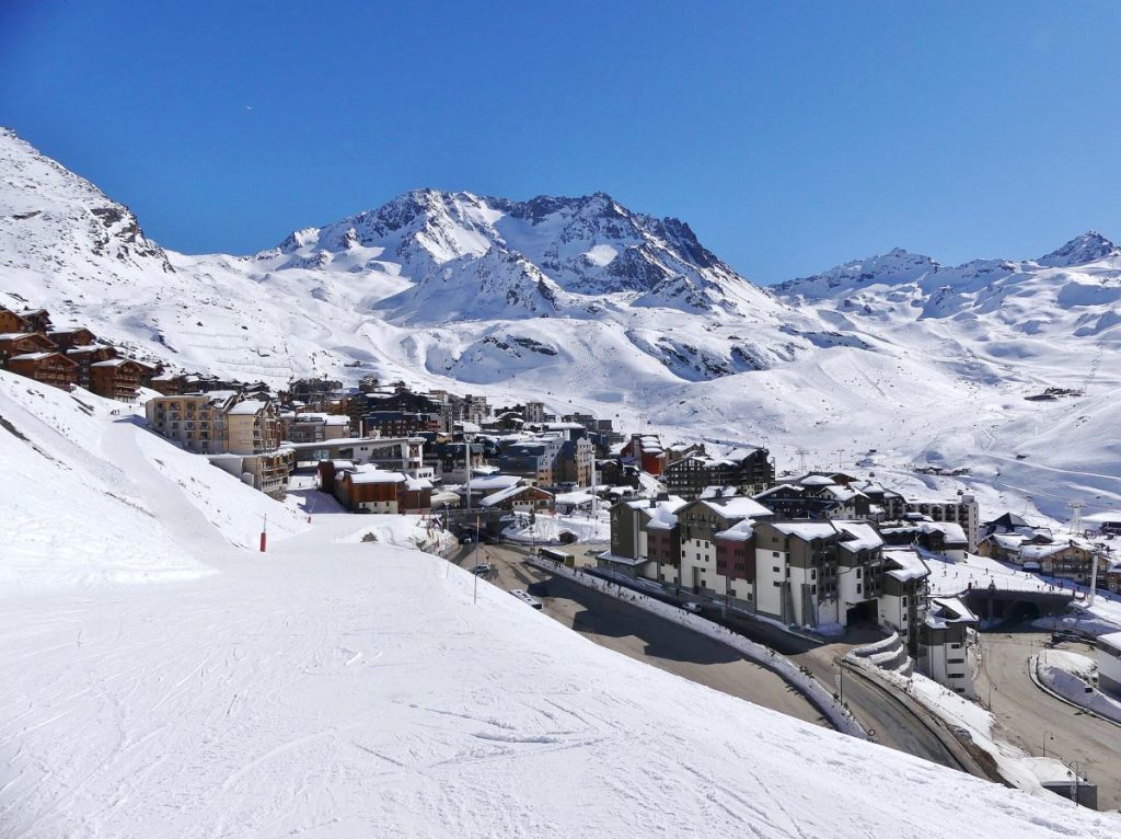 Vue hivernale de Val Thorens depuis le nord-ouest avec une piste de ski descendant vers la station