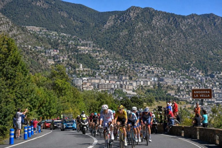 Peloton de la Vuelta 2026 dans une ascension en Andorre, avec Andorra la Vella et les montagnes en arrière-plan.