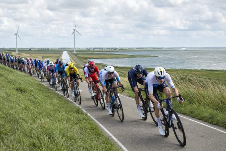 Peloton cycliste sur une route côtière exposée au vent en Zélande lors de l’étape 2 du ZLM Tour 2026.