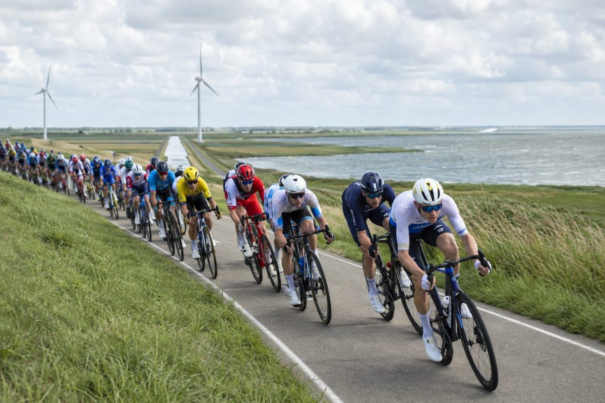 Peloton cycliste sur une route côtière exposée au vent en Zélande lors de l’étape 2 du ZLM Tour 2026.