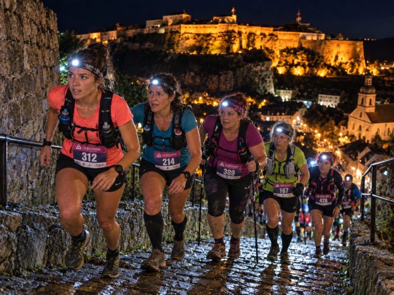 Traileuses de La Bitchoise 2026 courant de nuit à la frontale dans les rues de Bitche avec la citadelle illuminée en arrière-plan